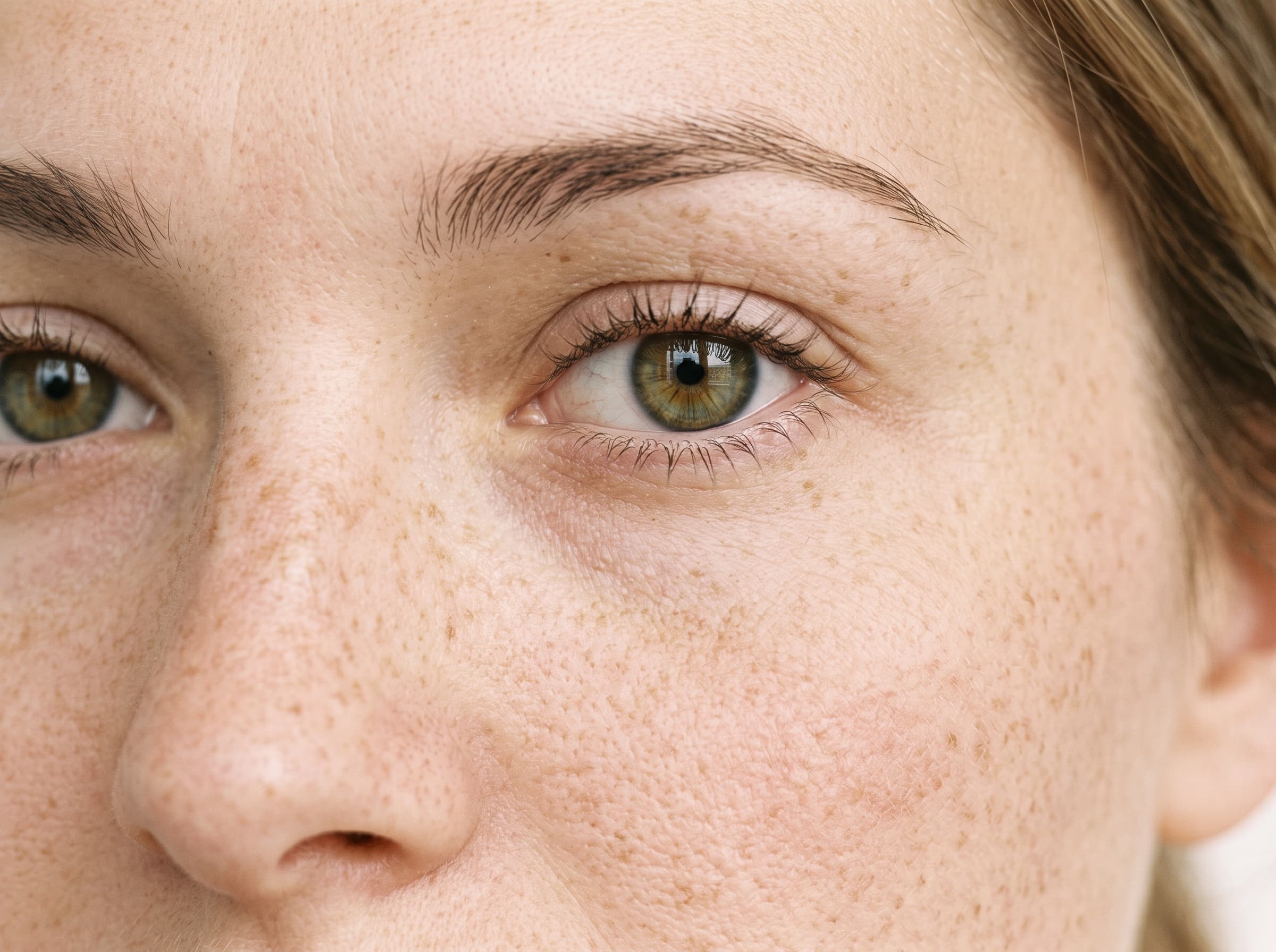AI influencer with light natural freckles across the nose and cheeks